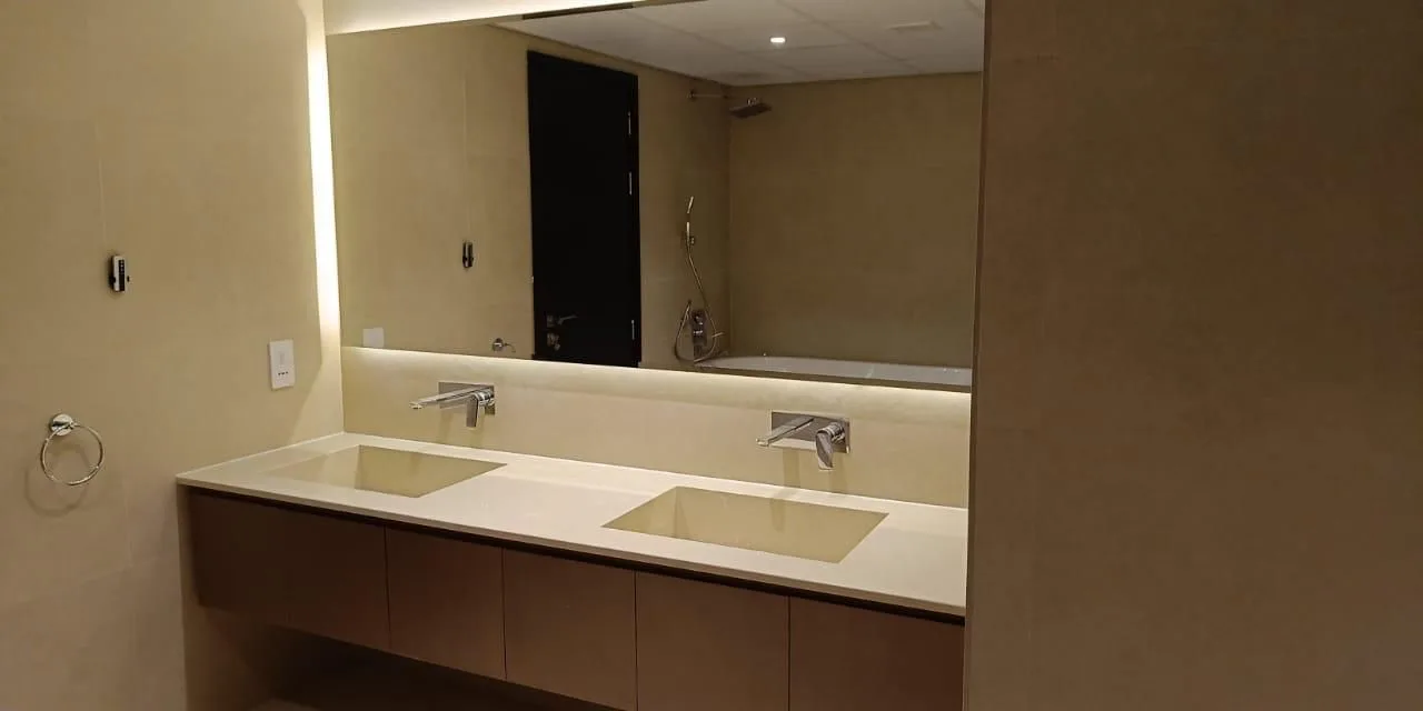 Large illuminated bathroom mirror above a twin basin vanity