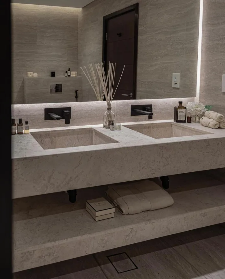 Backlit frameless vanity mirror above a double basin