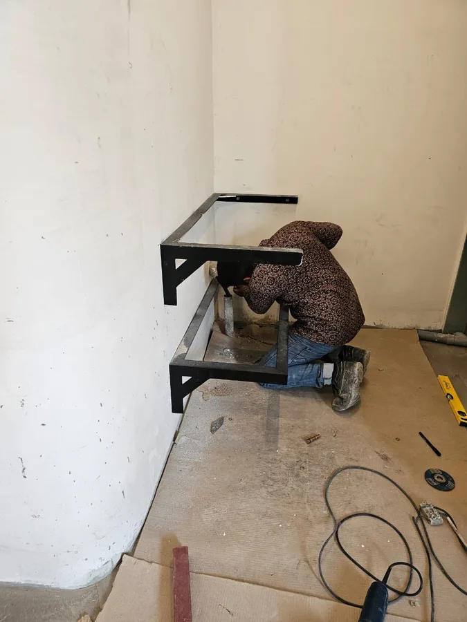 Technician assembling a black aluminium frame on site